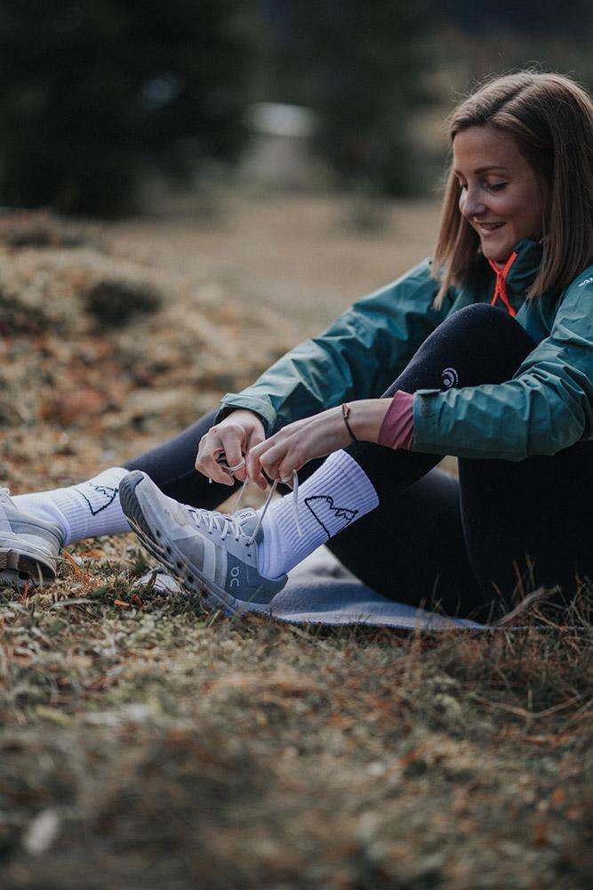 Model bindet sich die Schuhe in Hoamount Sportsocken